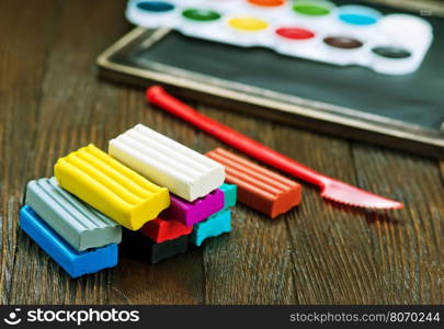 color plasticine on a table, plasticine on wooden background