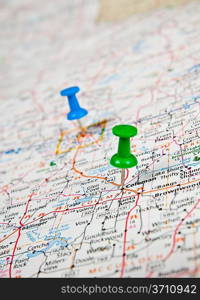 Color pushpins marking a location on a road map.