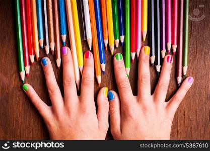 Color rainbow pencils and teenager&rsquo;s hands with multicoloured nails
