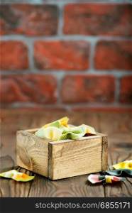 color raw pasta in wooden box and on a table