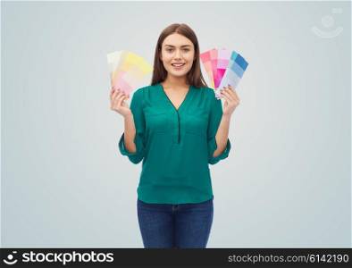 color scheme, decoration, design and people concept - smiling young woman with color swatches or samples over gray background
