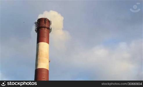 Color smoke comes out of the smokestacks at sunset. Air pollution.