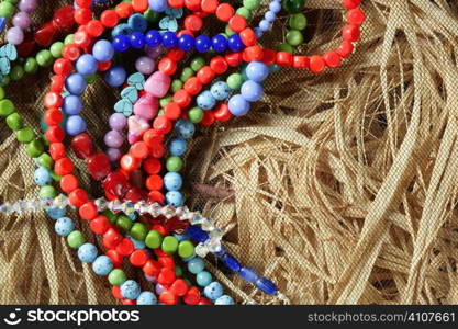 Color stones jewelry necklaces over natural straw and tulle background