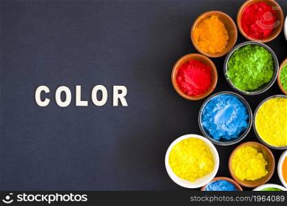 color text with different types holi color powder bowl black background. High resolution photo. color text with different types holi color powder bowl black background. High quality photo