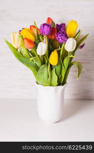 Color tulips in a white vase. Spring concept with copy space. Color tulips in the vase