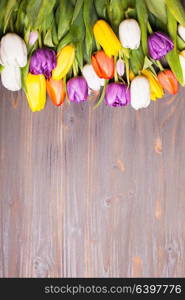 Color tulips on the rustic gray wooden board. Spring concept with copy space. Color tulips on the board