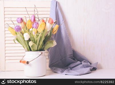 Color tulips with branches in a white cane. Spring decor. Color tulips in the cane