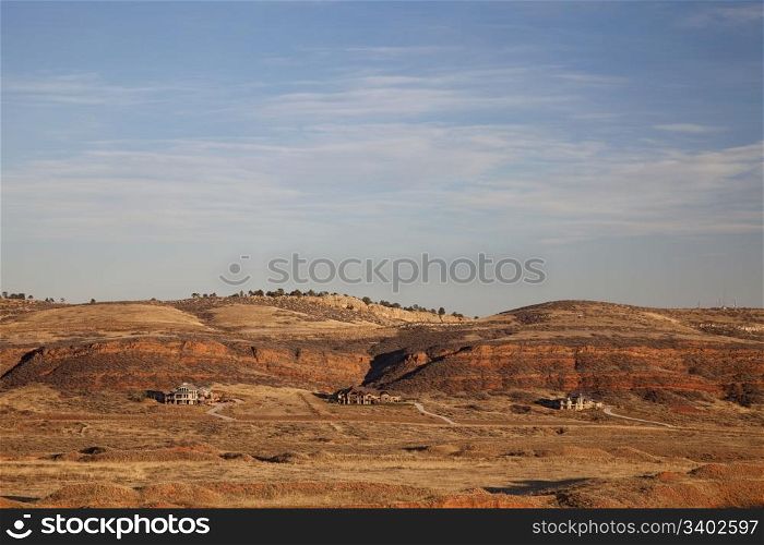 Colorado luxury houses at foothills of Rocky Mountains near Loveland, red sandstone cliffs, fall scenery at sunset with dry vegetation
