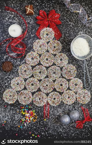 Colored chocolate rings with Christmas decoration on black stone table