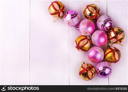 Colored Christmas decorations scattered on a white wooden table.