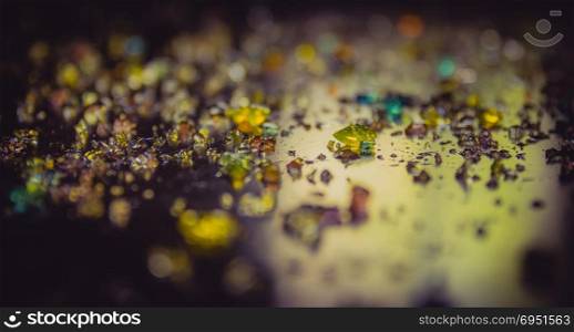 Colored diamonds scattered on a dark surface.Narrow focus.