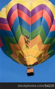 Colored hot-air balloon in flight against a blue sky. Colored hot-air balloon in flight