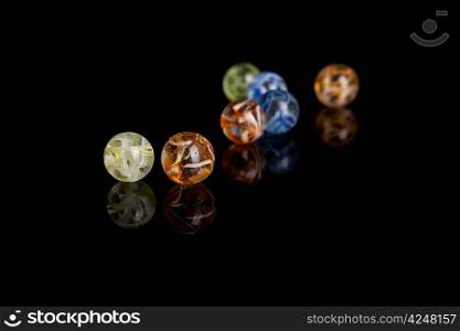 Colored marbles isolated over black background