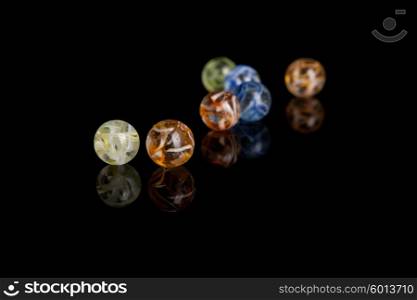 Colored marbles isolated over black background