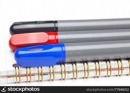 colored markers and a notebook isolated on white