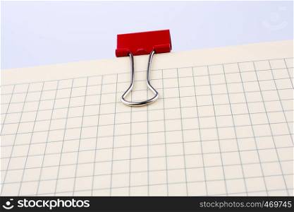 Colored paper clip on a checked notebook page