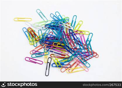 Colored paper clips group on the white desktop background, Stationery office supplies concepts.