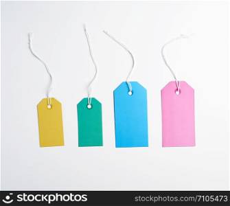 colored paper tags on a white rope, white background, close up