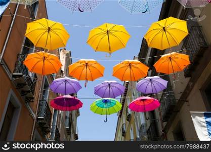 Colored parasols in the streets of Iglesias, Sardinia, Italy