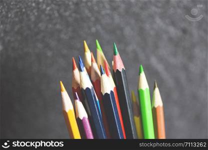 Colored pencil set on blackboard back to school and education concept / Crayons colorful
