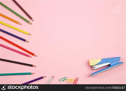 colored pencils and stationery on pink isolated background. top view. flat lay. mockup