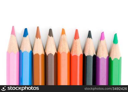 Colored pencils lined up on a white background