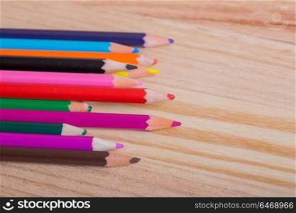 colored pencils on the wooden background