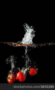 Colored red paprika in water splashes on black background