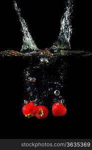 Colored red paprika in water splashes on black background