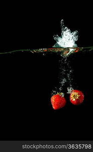 Colored red paprika in water splashes on black background