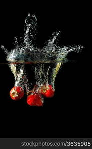 Colored red paprika in water splashes on black background