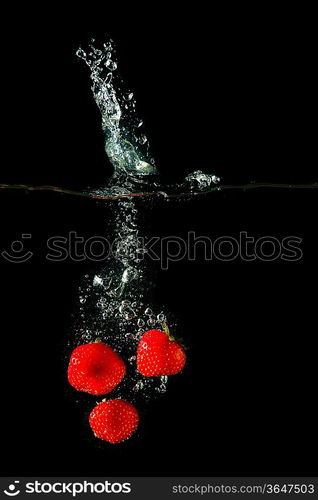 Colored red paprika in water splashes on black background