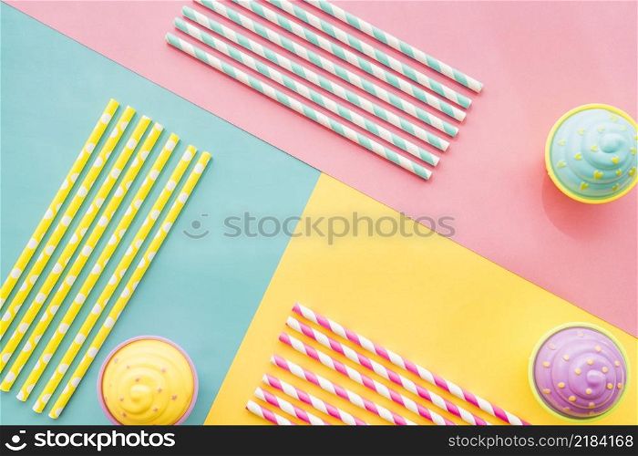 colored surface with birthday cupcakes straws