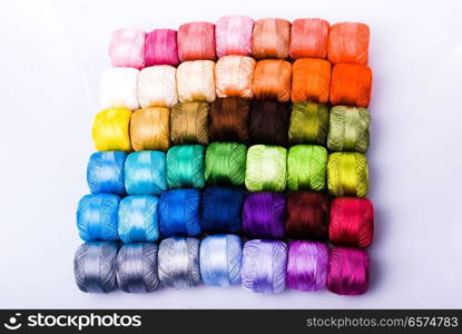 Colored threads to your liking. The top view of a multi-colored filaments, arranged in a row on a white background