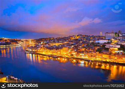 Colorful afterglow skyline of Porto illuminated old town with clouds, reflecting in Douro river, Portugal
