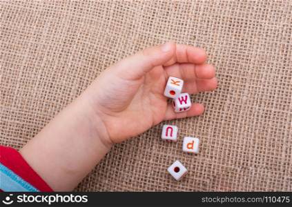 Colorful alphabet letter cubes in handon a canvas background
