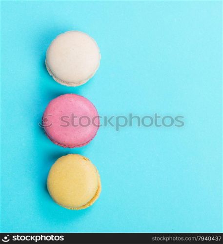 Colorful and tasty French Macarons on blue background.Top view.