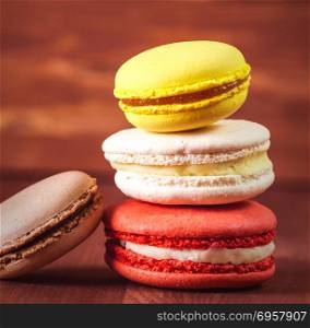 Colorful and tasty pasta on a wooden background.. Stack of colorful macaroons on a wooden background