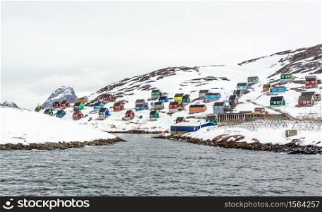 Colorful arctic fishing village houses at the rocky fjord in the middle of nowhere, Kangamiut, Greenland