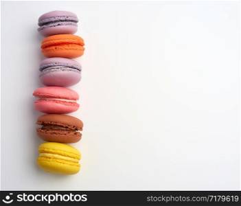 colorful baked macarons almond flour on a white background, copy space, flat lay