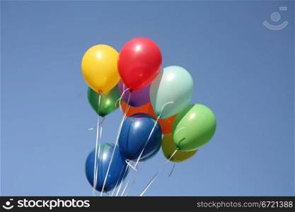 Colorful balloons dancing in a blue sky
