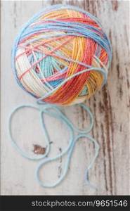 Colorful balls of yarn for knitting on white wooden table