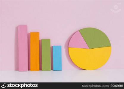 colorful bar graph pie chart desk pink background. Beautiful photo. colorful bar graph pie chart desk pink background