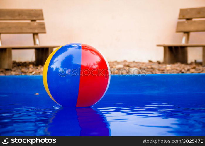 Colorful beach ball floating in pool.