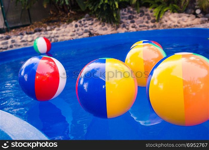 Colorful beach balls floating in pool.