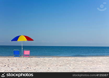 Colorful Beach Umbrella with Pink and Blue Deckchairs