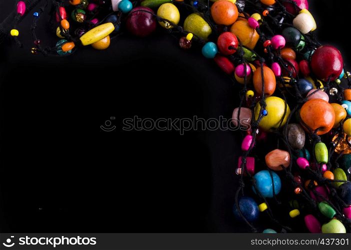 Colorful beads necklace frame on black background with copy space