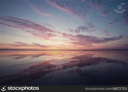 Colorful beautiful cloudy sunset over ocean surface