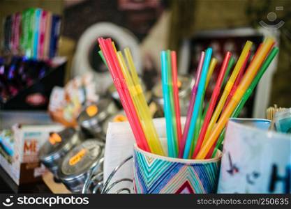 Colorful beverage tubes on coffee house background