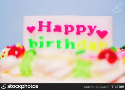 Colorful birthday cake with label of happy birthday and heart shaped Close up